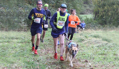 Pam in Blind Vest & Maida in unifly run in a trail race.