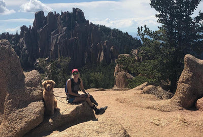 Allysa Seely sits with her service dog on a hike. 