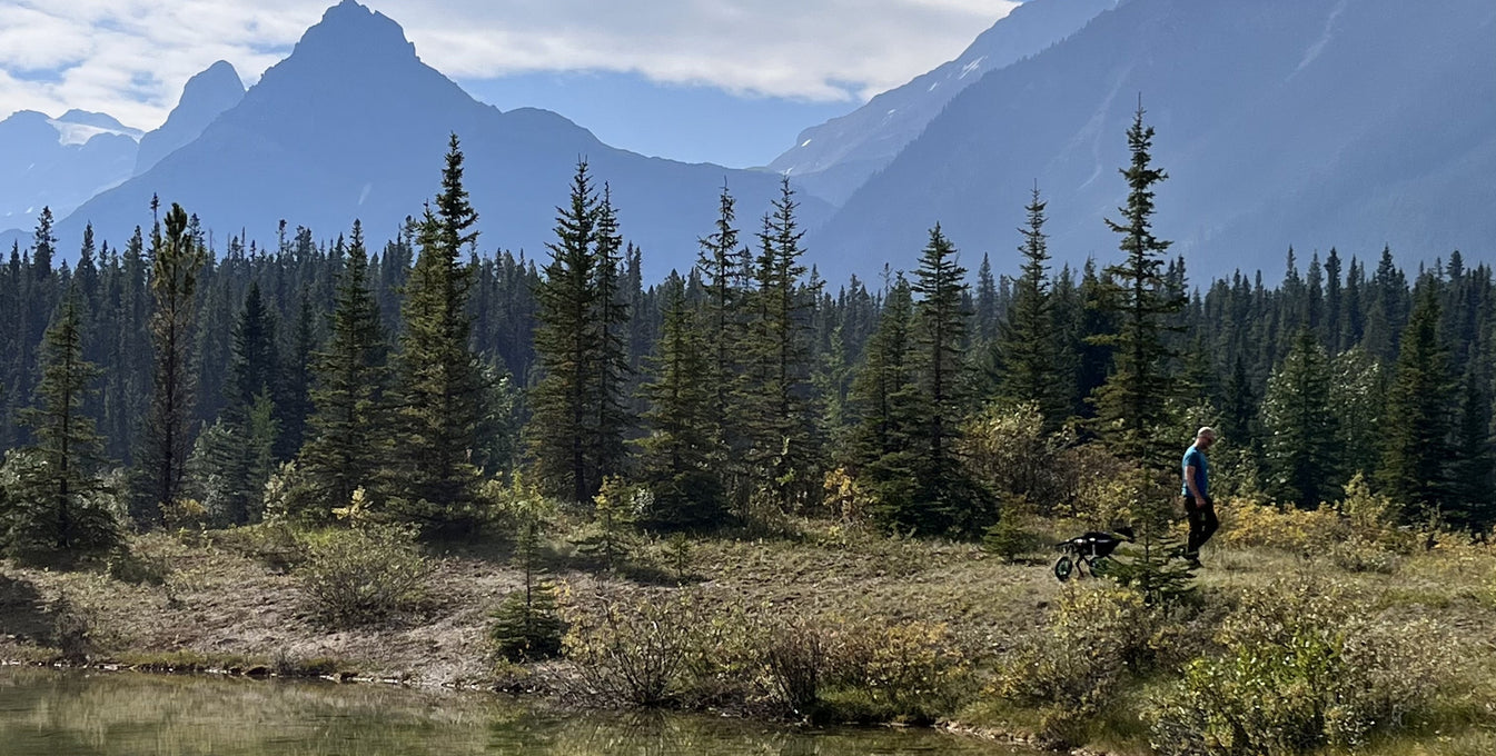 A man and his dog hike in the Canadian Rockies.