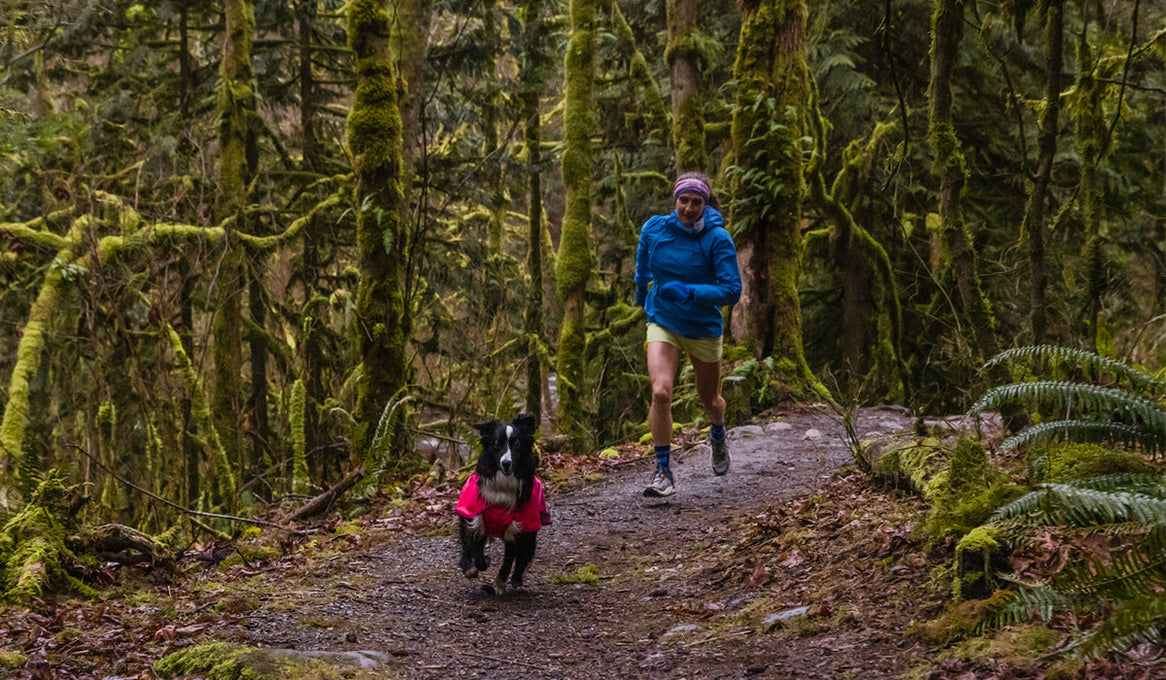 Krissy and her dog PD running on a muddy trail