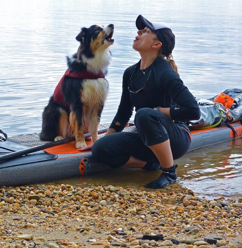 Maria and Kona howl to the sky sitting on a SUP.