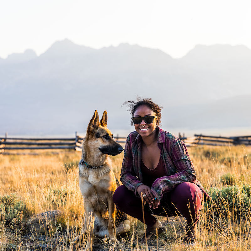 Noami and Amara in a grassy field in front of the mountains.